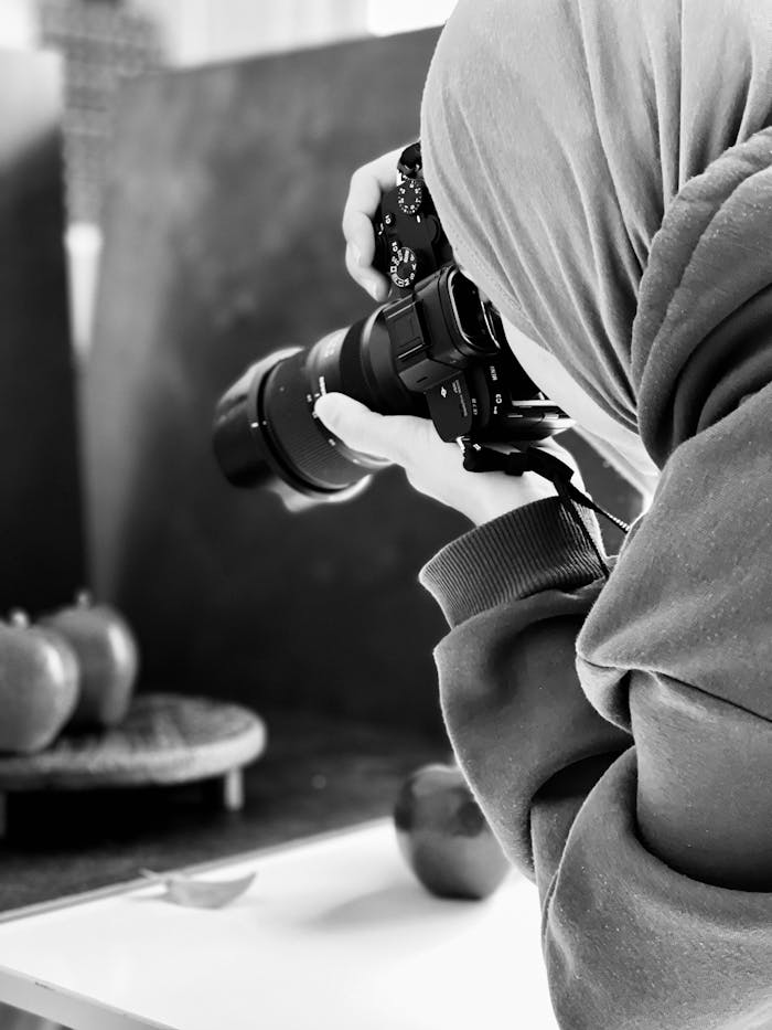 Focused photographer capturing a still life image in a studio setting.