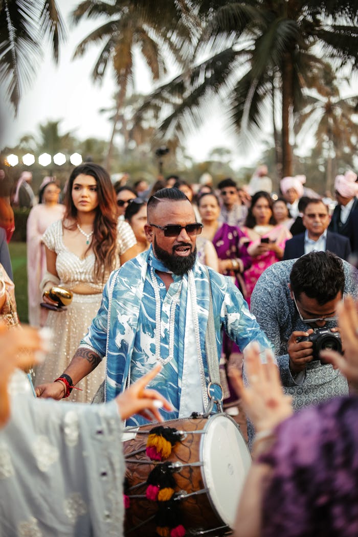 Chi siamo Energetic celebration at an Indian wedding featuring a drummer amidst a lively crowd in Goa, India.